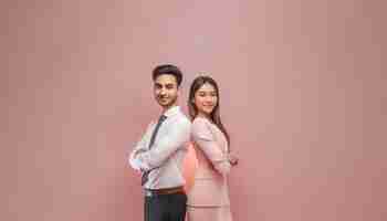 Photo portrait of a happy business couple standing with arms crossed over pink background