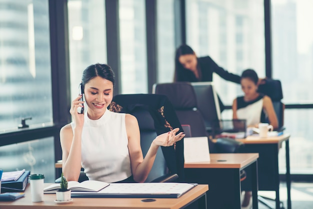 Portrait of a happy business woman sitting at her workplace in office