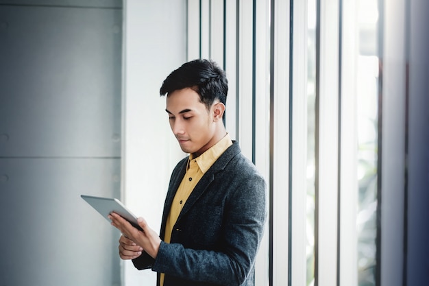 Portrait of Happy Businessman Standing by the Window in Office. 