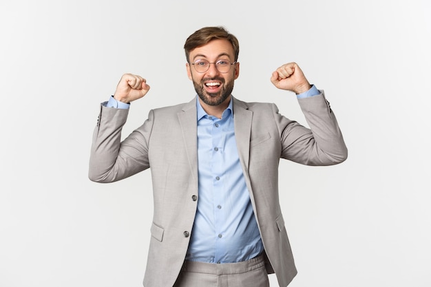 Portrait of happy businessman with beard, wearing grey suit and glasses