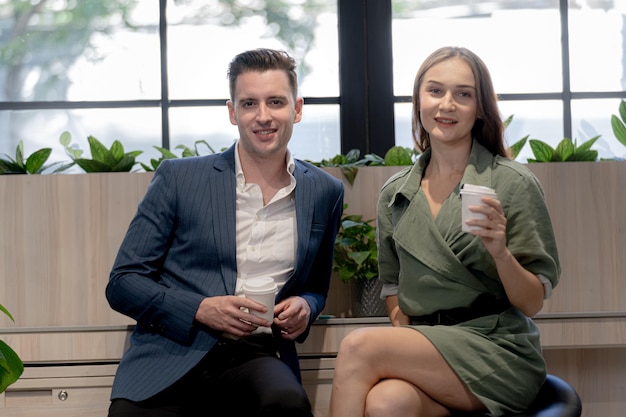 Portrait of happy businessman and woman hold cup of coffee at coffee cafe counter bat with nature biophilia for wellness life