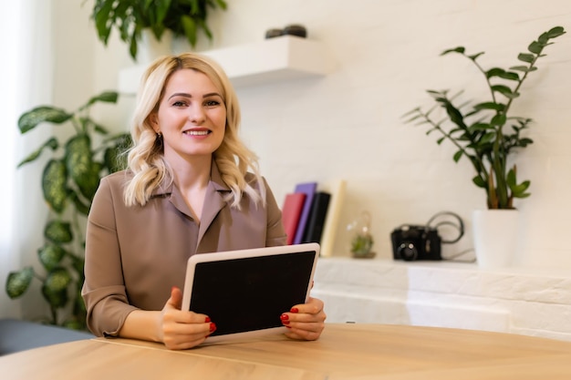 Portrait of a happy casual businesswoman sitting at her workplace in office