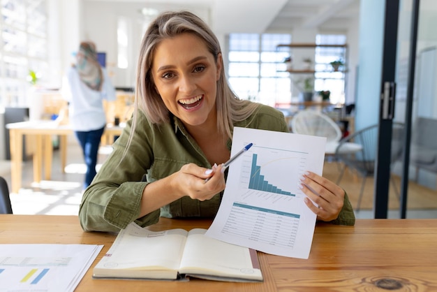 portrait of happy casual caucasian businesswoman having video call in modern office