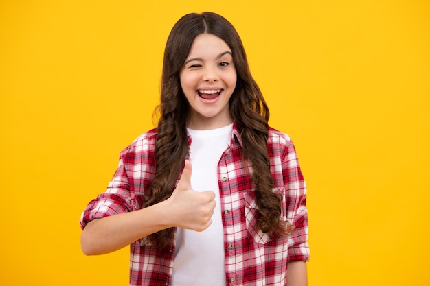 Portrait of a happy casual teenager child girl showing thumbs up and smiling happy teenager positive and smiling emotions of teen girl