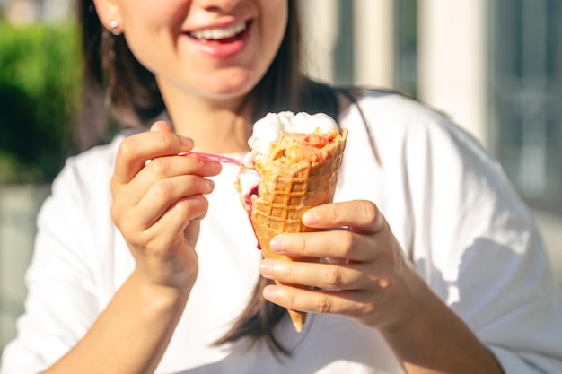 Foto ritratto di una felice donna bruna caucasica che mangia un cono di gelato