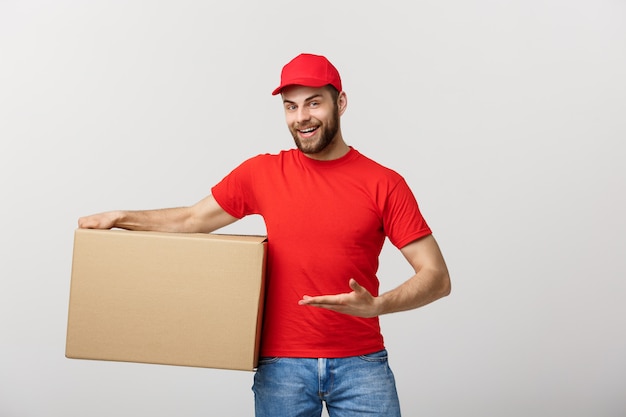 Portrait of Happy Caucasian delivery man pointing hand to present a box package.