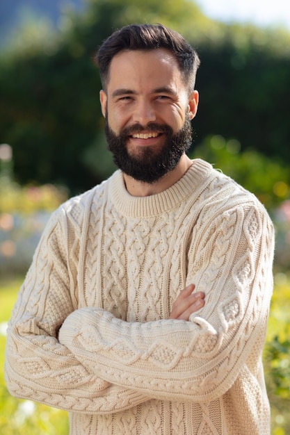 Foto ritratto di uomo caucasico felice con la barba che sorride alla macchina fotografica in giardino. concetto di vita domestica, salute e felicità.