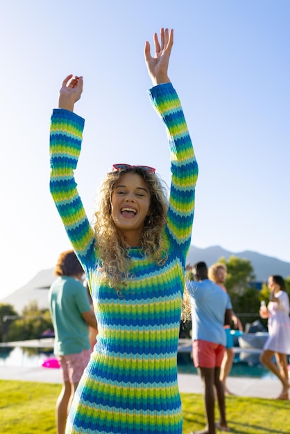 Portrait of happy caucasian woman dancing with her friends at party in garden. Lifestyle, friendship and party, summer, sunshine, unaltered.