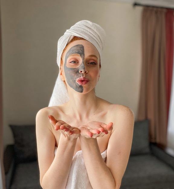 Foto ritratto di una donna caucasica felice con una maschera di argilla naturale