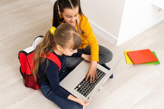 ノートブック、小学校を保持しているバックパックを持つ幸せな白人の若い女の子の肖像画。