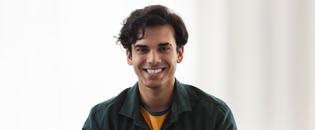 Portrait of happy caucasian young man looking at the camera and smiling