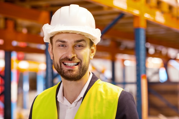 Ritratto di un uomo allegro e felice che sorride mentre indossa un'uniforme da lavoro