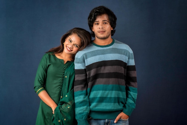 Portrait of a happy cheerful young couple posing on dark background Attractive man and woman being playful