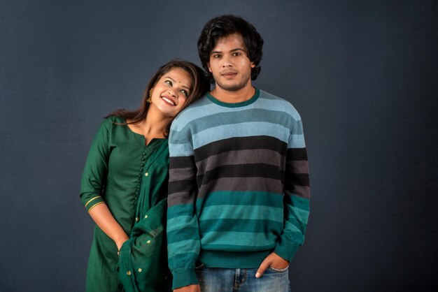 Portrait of a happy cheerful young couple posing on dark background Attractive man and woman being playful