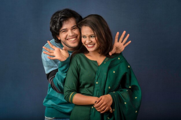 Portrait of a happy cheerful young couple posing on dark background Attractive man and woman being playful