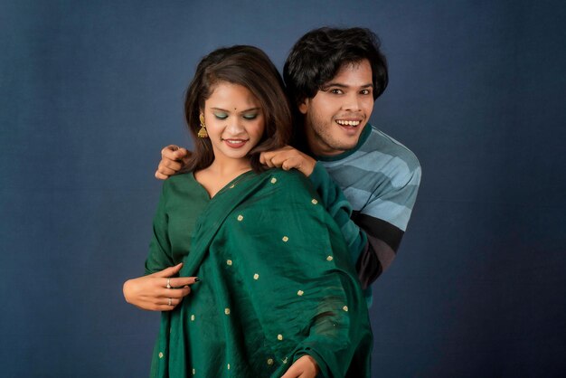 Portrait of a happy cheerful young couple posing on dark background Attractive man and woman being playful