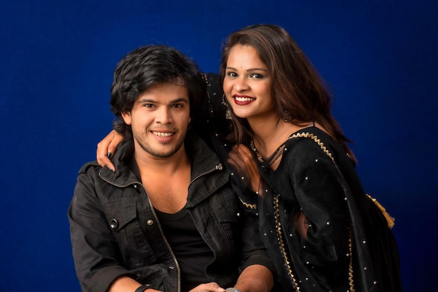 Portrait of a happy cheerful young couple posing on dark background Attractive man and woman being playful