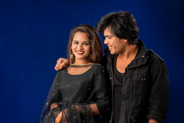 Portrait of a happy cheerful young couple posing on dark background Attractive man and woman being playful