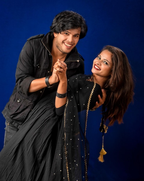 Portrait of a happy cheerful young couple posing on dark background Attractive man and woman being playful