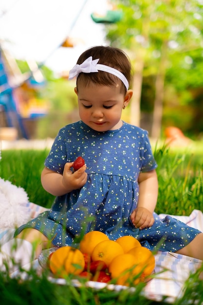 夏のピクニック、自然、ライフスタイル、家族の日に屋外でオレンジを食べる幸せな子供の肖像画