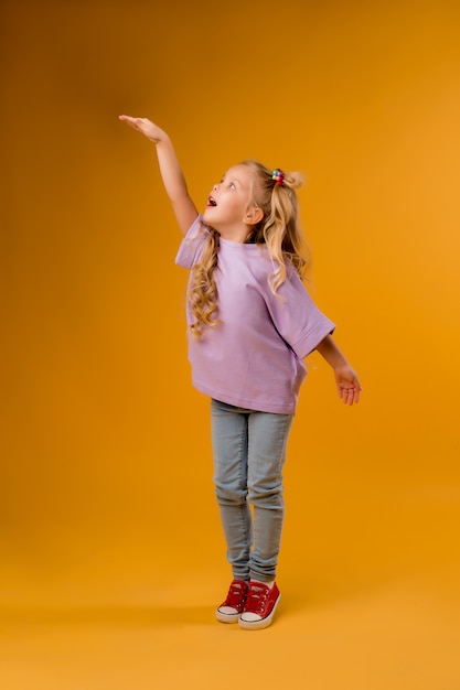 Портрет счастливого ребенка девушка изолировать на желтом пространстве, пространство для текста