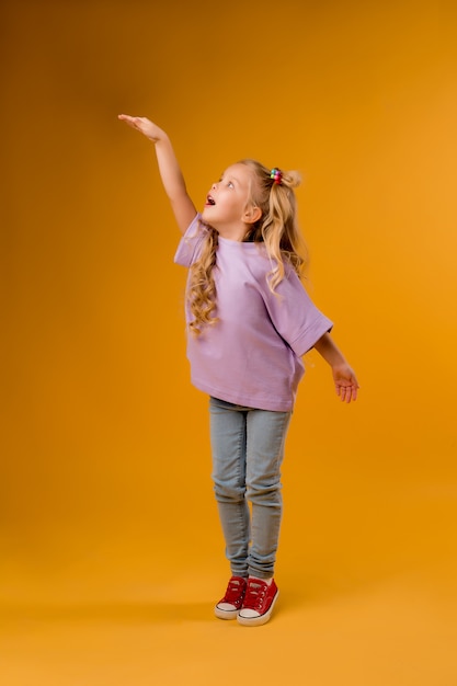 portrait of a happy child girl isolate on a yellow space, space for text