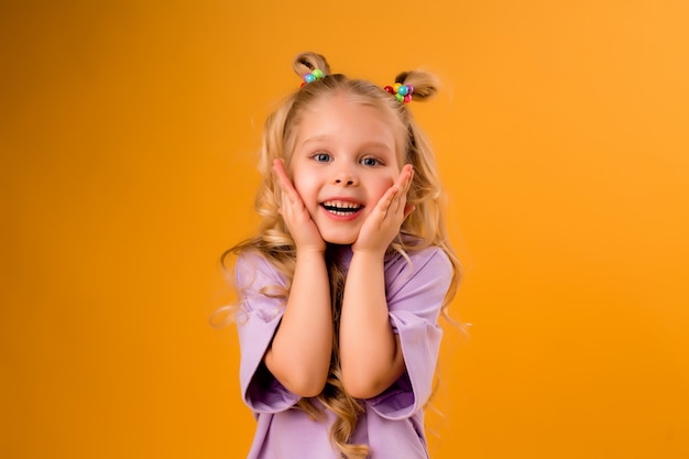 portrait of a happy child girl isolate on a yellow space, space for text