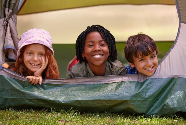 Photo portrait happy and children in tent for camp on vacation adventure or holiday with fun smile travel and young kids bonding together in outdoor field forest or woods on summer weekend trip