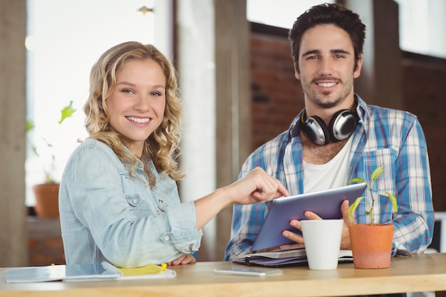 Portrait of happy colleague with digital tablet in office