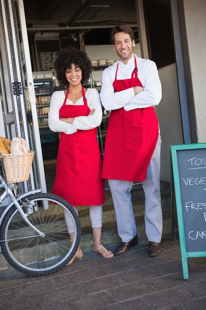 Portrait of happy colleagues in red apron posing