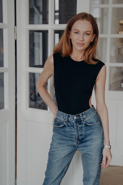 Portrait of happy confident middle age young woman Lady is standing near door window