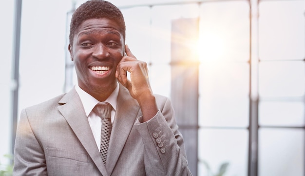 Portrait of a happy confident young african american businessman standing with his arms crossed looking at camera