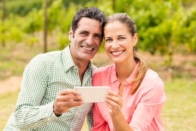 Portrait of happy couple holding mobile phone