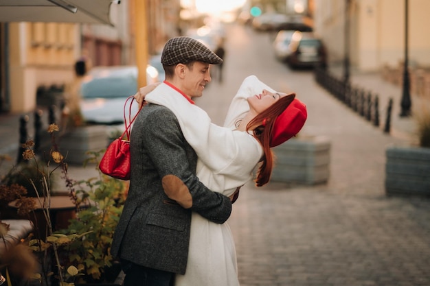 Portrait of a happy couple hugging on the street in an autumn\
city retro stylish couple in autumn in the city