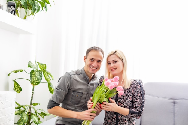 Ritratto di coppia felice, marito e moglie con bouquet di fiori primaverili