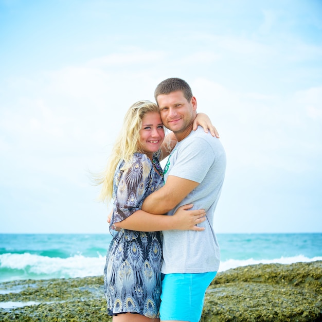 Portrait of happy couple in love on the beach at summer day