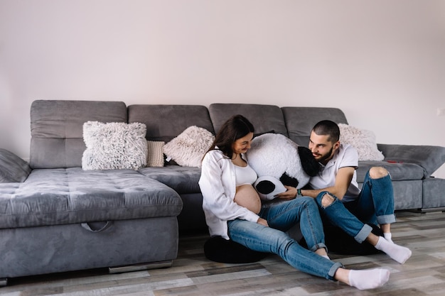 Portrait of happy couple in pregnant with teddy bear