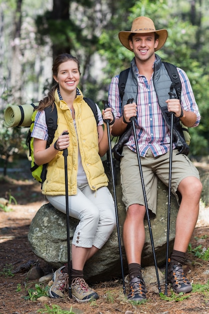 Portrait of happy couple sitting on rock during hiking 