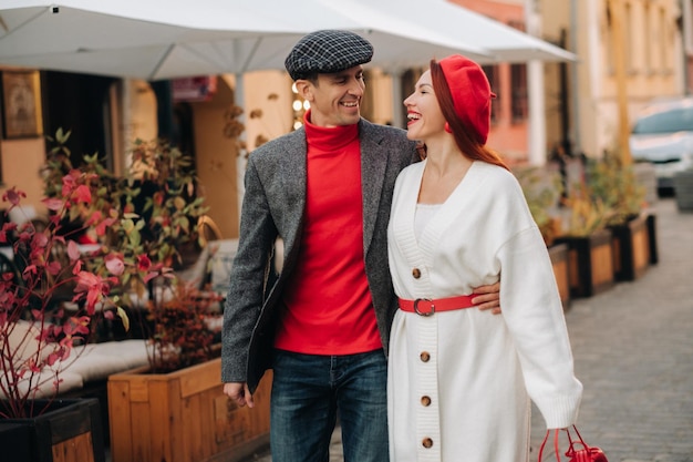 Portrait of a happy couple walking on the street in an autumn\
city stylish couple in retro style in autumn in the city