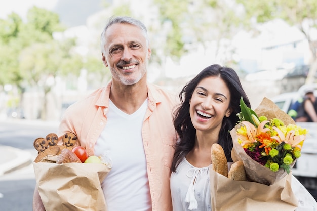 Portrait of happy couple with grocery bags