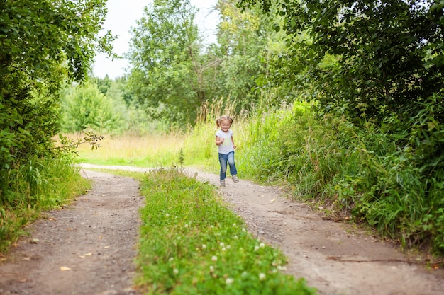 Portrait of happy cute little girl outdoor Kid playing running in park or garden