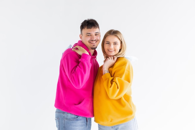 Portrait of happy cute lovers embracing on gray background holding medical safety sterile mask