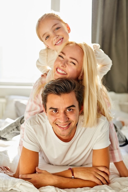 Portrait of happy family on bed, they have rest, enjoy time together in the morning at home