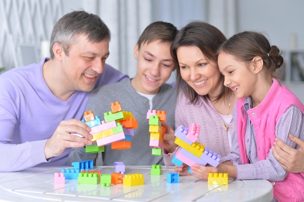 Portrait of a happy family collecting colorful blocks together