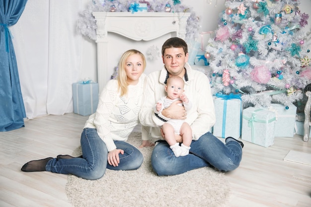 Portrait of happy family in front of christmas tree