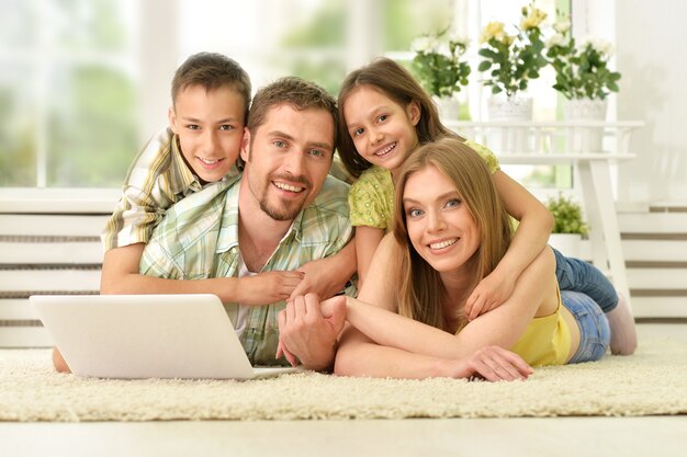 portrait of happy family at home with laptop