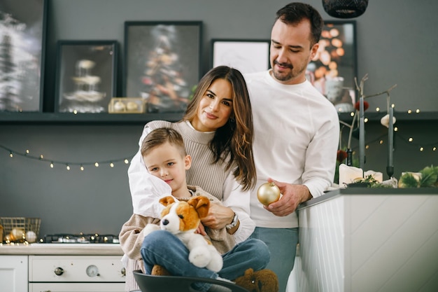 A portrait of happy family in the kitchen decorated for christmas