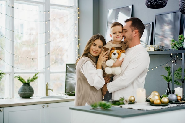 A portrait of happy family in the kitchen decorated for christmas