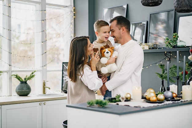 A portrait of happy family in the kitchen decorated for christmas