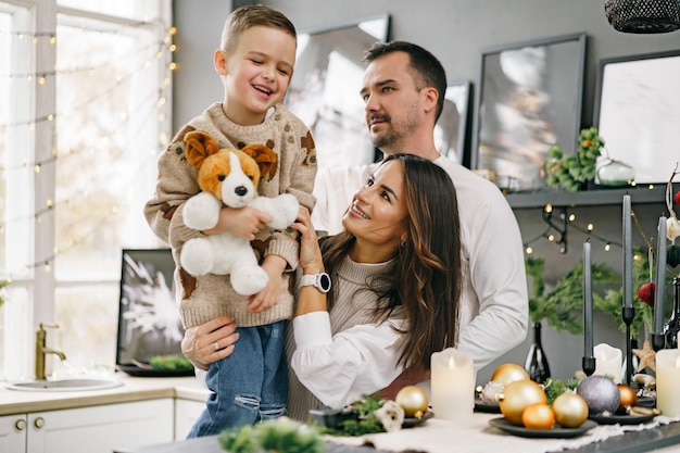 A portrait of happy family in the kitchen decorated for christmas